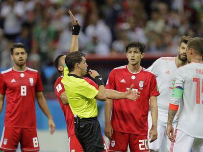 Los jugadores de Irán y de España esperan la resolución del VAR sobre un posible gol.
