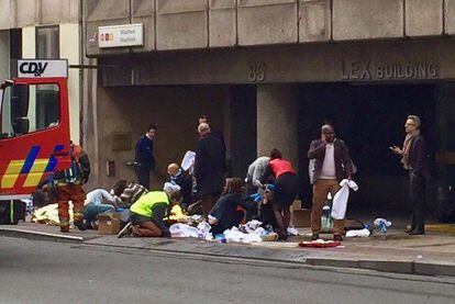 Personal sanitari ajuda diverses persones a l'exterior de l'estació de metro de Malbeek a Brussel·les.  


