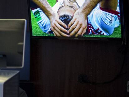 Un operador de la Bolsa de Nueva York con el partido entre Ir&aacute;n y Portugal  del Mundial de F&uacute;tbol en pantalla