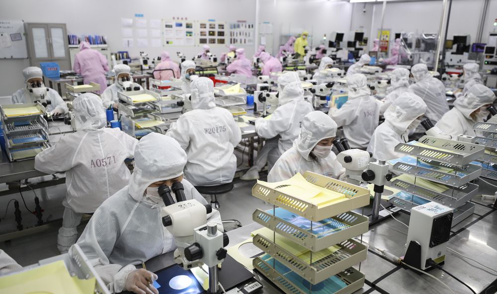 Empleados trabajan en una línea de producción de chips de Huanan.