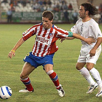 Fernando Torres controla el balón acosado por el defensa del Albacete Peña.