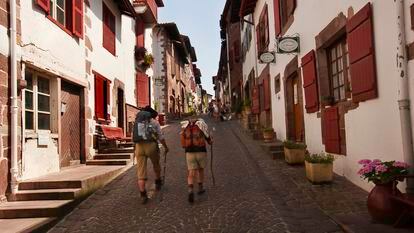 Dos peregrinos del Camino de Santiago en una calle de Saint-Jean-Pied-de-Port, en el País Vasco francés.
