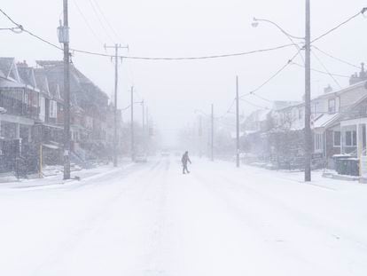Un hombre cruza la calle durante la tormenta de nieve en Ontario, Canadá.