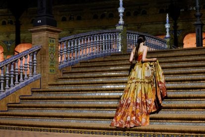 Una modelo sube las escaleras de la plaza de España de la localidad hispalense durante el desfile.