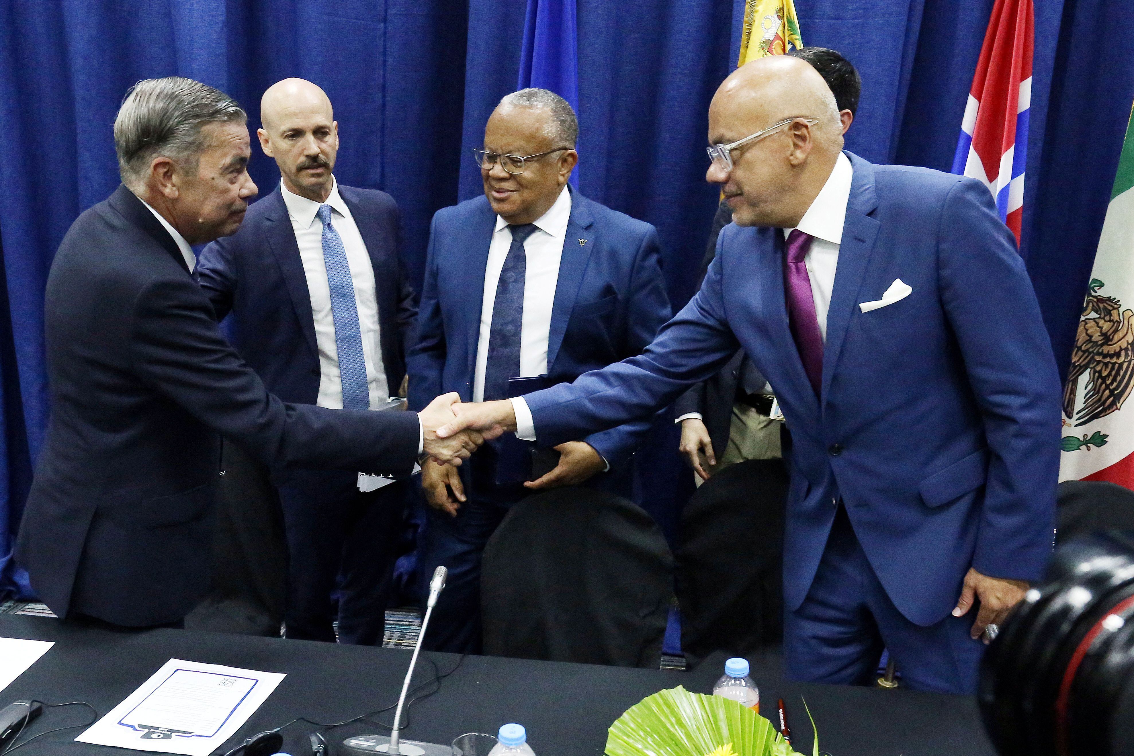 Gerardo Blyde, de la oposición venezolana, saluda a Jorge Rodríguez, tras firmar un acuerdo de garantías electorales en octubre de 2023, en Barbados.