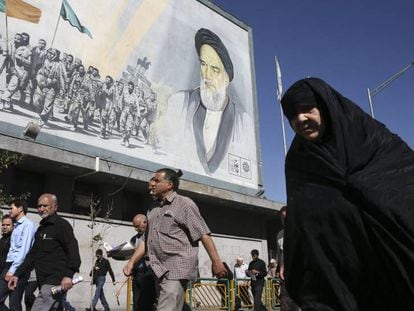 Iran&iacute;es pasan frente a una pintura del ayatol&aacute; Jomeini en Teher&aacute;n, Ir&aacute;n.