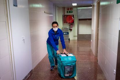 La enfermera Mireia Gispert llega al área de quirófanos con la nevera que guarda el corazón donado.