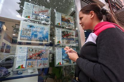Una mujer apunta en una libreta los pisos en alquiler de una inmobiliaria madrileña.