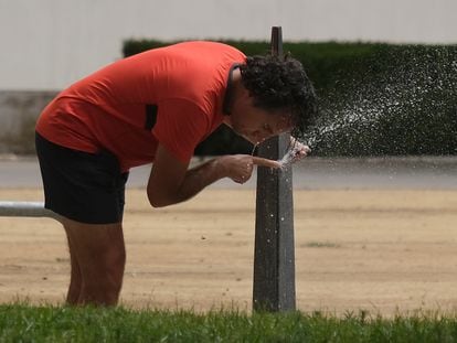 Un hombre se refresca en una fuente en Sevilla, este domingo.