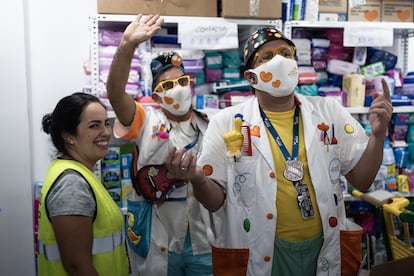 Los artistas hospitalarios del proyecto Sonrisas de Emergencia Wame Gutiérrez (Dr. Mocito) (C) y Daniel Mesa (Dr. Yo), junto a Cristina González, responsable de servicios sociales en el Banco de alimentos en La Palma, fotografiados en El Paso, La Palma.