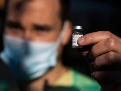 Un sanitario gallego sostiene una vacuna.