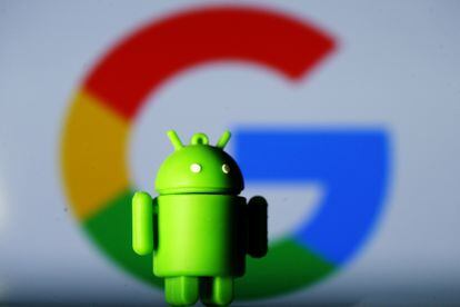 Una muñeca Android, el sistema operativo móvil de Google, delante del logotipo de la empresa.