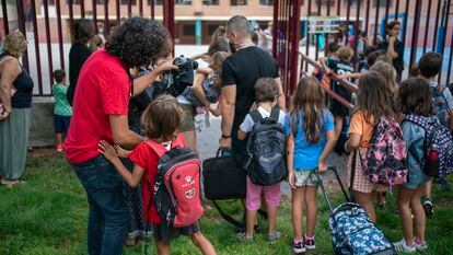 Varios padres se despiden de sus hijos a la entrada del colegio en el primer día de clase en Madrid.