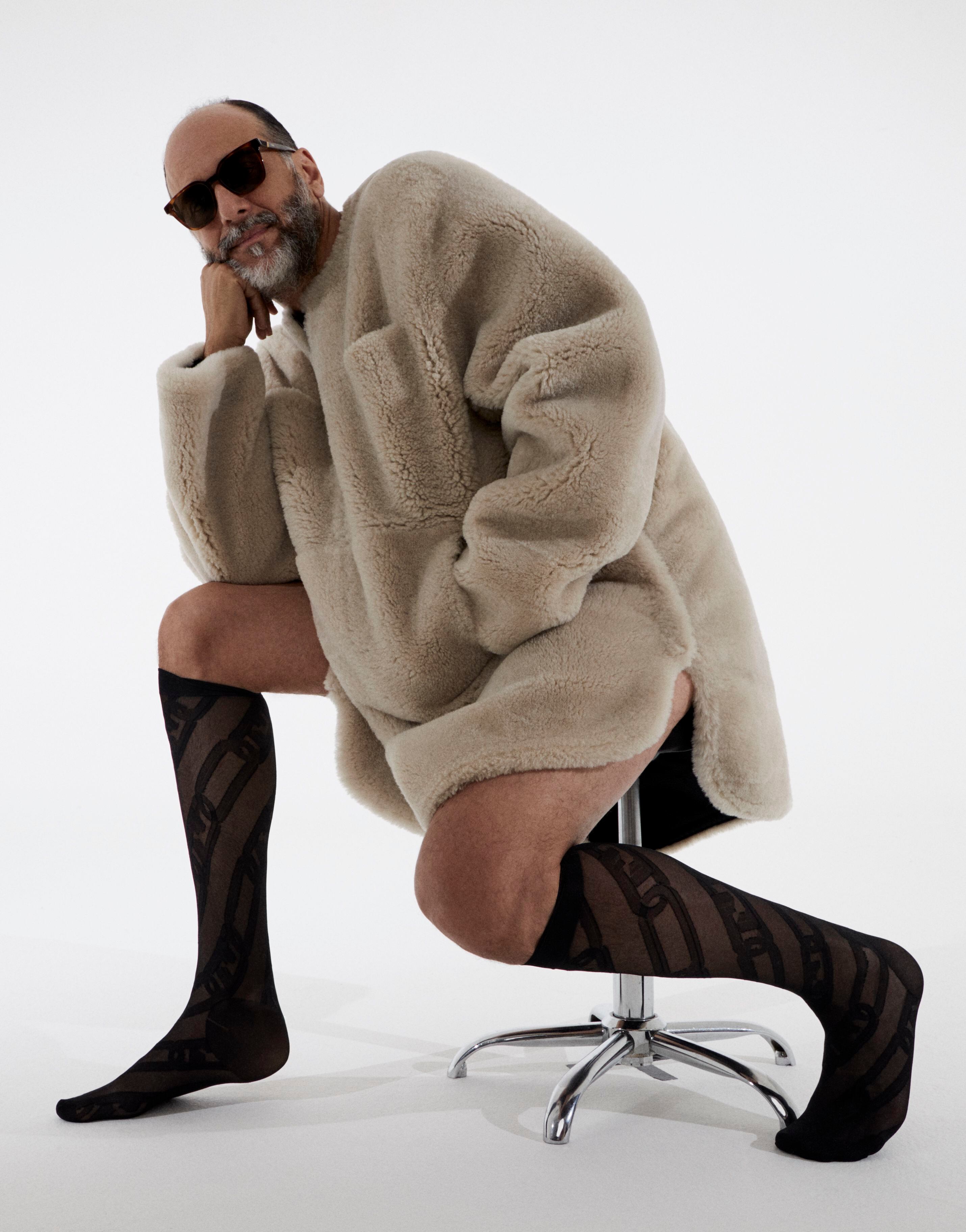 Luca Guadagnino con abrigo de piel de oveja beis, gafas de sol y calcetines, también de Fendi.