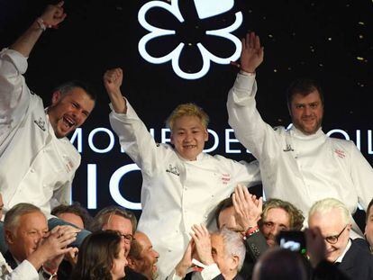 Los tres cocineros galardonados con tres estrellas Michelin, junto al resto de sus compañeros, en París, este lunes.