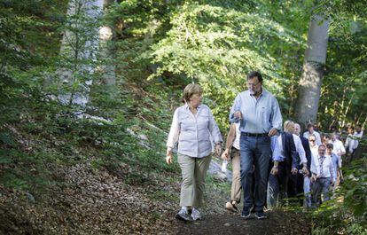 El presidente del Gobierno, Mariano Rajoy, y la canciller alemana, Angela Merkel, recorren un tramo del Camino de Santiago, en 2014.