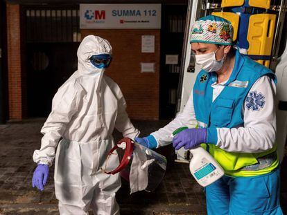 Miembros del equipo sanitario del Summa realizan el proceso de colocación y retiro de un EPI completo, durante su guardia de 24 horas en el Centro de Salud Las Águilas en Madrid.