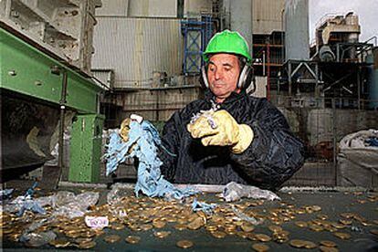Un empleado de Elmet, en plena labor de reciclaje de monedas de peseta.