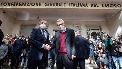 El primer ministro de Italia, Mario Draghi (izquierda), saluda este lunes al secretario general de CGIL, Maurizio Landini, frente a la sede en Roma del sindicato atacado este fin de semana por grupos fascistas.