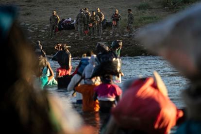 Un grupo de migrantes haitianos cruza el Río Bravo hacia Del Río (Texas), donde los reciben miembros del Ejército estadounidense.