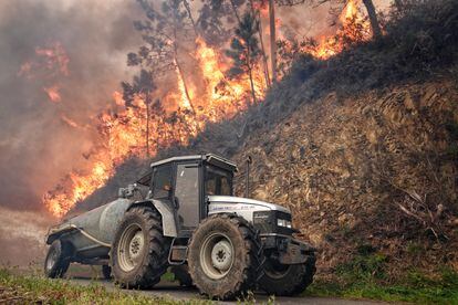 Un tractor trabaja en la extinción del incendio de los concejos asturianos de Valdés y Tineo, el jueves.