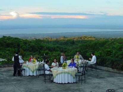 Un grupo de personas cena en el restaurante en la cima de Managua