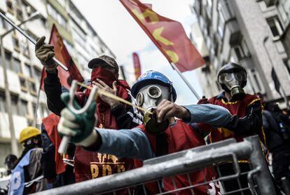 Un manifestante turco con máscara de gas apunta con un tirachinas a los antidisturbios.