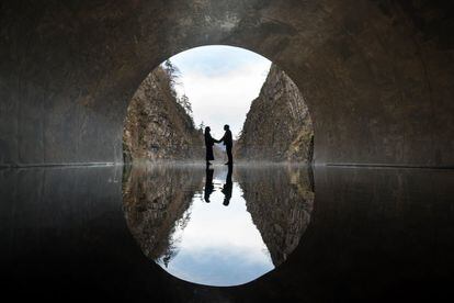 Dos visitantes posan para una fotografía en una plataforma de observación con la obra de arte 'Tunnel of Light' (Echigo-Tsumari Art Field) de Ma Yansong / MAD Architects en Kiyotsu-kyo Gorge, en Tokamachi , Japón.