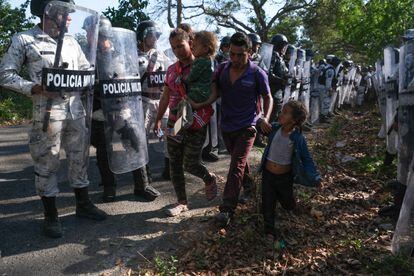 Una familia hondureña es retenida por la Guardia Nacional en uno de los controles carreteros instalado en Chiapas. 