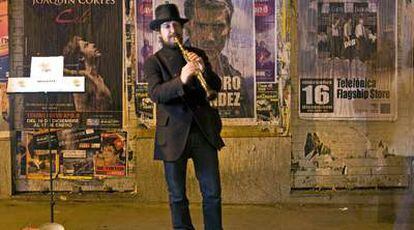 El músico Nacho Mastretta toca el clarinete en la calle de Fuencarral el pasado viernes.