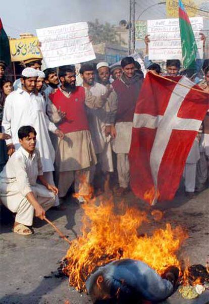 Varios musulmanes queman una bandera danesa durante una protesta contra Dinamarca y Francia en Multan, Pakistán.