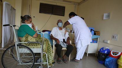 Una enfermera inyecta una vacuna contra la covid a un anciano en el Raman Hospital de Bangalore (India).