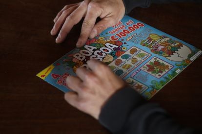 A man scratches on a Portuguese lottery ticket. 
