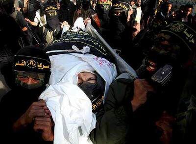Hombres armados llevan a hombros el cadáver de un militante de la Yihad Islámica durante su funeral en el sur de la franja de Gaza.