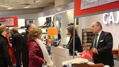 Varias personas realizan compras en un centro comercial.