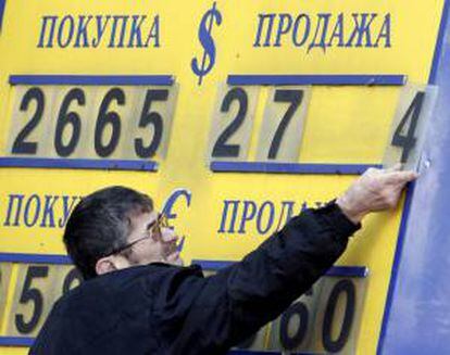 Un trabajador de una oficina de cambio coloca unas placas para formar las cifras del cambio dólar-rublo en Moscú, Rusia.