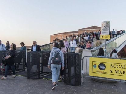 Los turistas pasan a través de los tornos que regularán la afluencia de visitantes en Venecia.