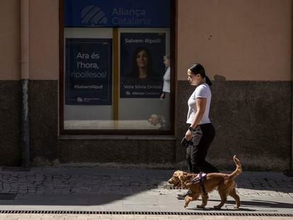 Un mujer pasea a su perro en Ripoll frente a la sede de Aliança Catalana.
