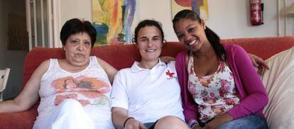 En un piso de acogida en Madrid: Rosa Pérez (izquierda), que espera un corazón para su hijo; Marta Gasca, de Cruz Roja, y Ana Tavárez, cuyo hijo ya ha sido trasplantado. / Alvaro Garcia (EL PAÍS)