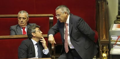 El concejal de Seguridad Ciudadana, Miquel Domínguez (de pie), habla con el de Juventud, Cristóbal Grau, durante el pleno de Valencia.
