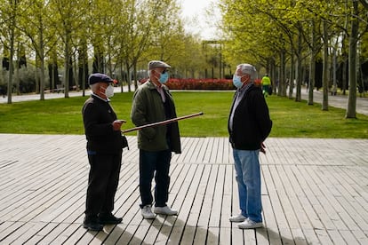 Tres hombres conversan a finales de marzo en el Parque Lineal del Manzanares en Madrid.