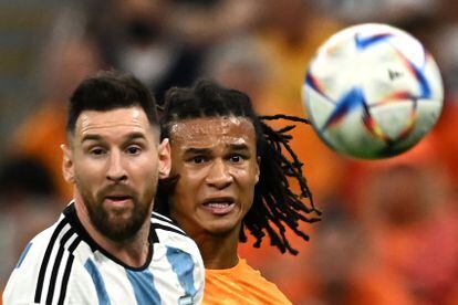 Lionel Messi and Nathan Ake fight for a ball. 