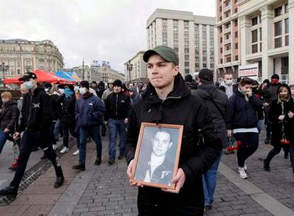 Un miembro de una organización antifascista sostiene una fotografía del líder del movimiento, Iván Jutorskói, durante un acto en su memoria.