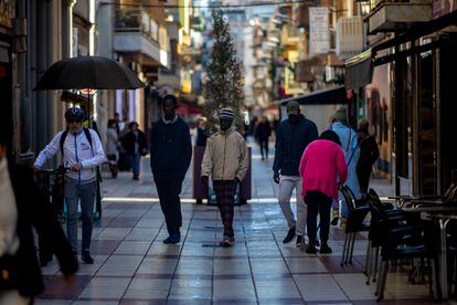 Several people of sub-Saharan origin walk down a street in Calella.  Kike Rincón.