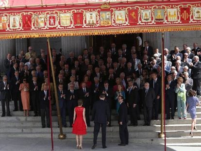 Parlamentarios de las Cortes Constituyentes de 1977, junto a Mariano Rajoy y otros cargos actuales, aplauden a los Reyes, en la escalinata de entrada al Congreso.