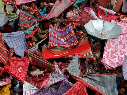 Devotos hindúes colocan los paraguas para recoger arroz durante el festival Annakut, en Calcuta (India).