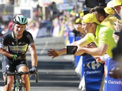 Mark Cavendish se sujeta el brazo derecho al cruzar la meta en Harrogate.