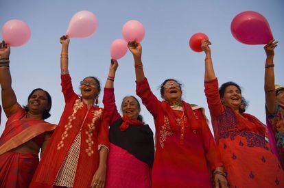 Un grupo de mujeres indias agitan globos durante una función para celebrar el Día de San Valentín en la playa Girgaon Chowpatty, en Mumbai.
