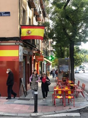 Exterior del bar Los Sesenta en el madrileño Paseo de Extremadura, donde llaman la atención las mesas pintadas con los colores y franjas de la bandera española. 