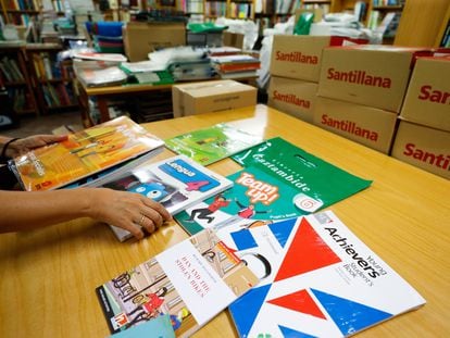 Un docente organiza los libros de texto para el inicio de curso en un centro de Madrid.